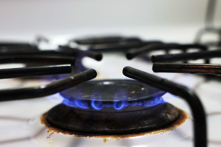 A close-up of a lit gas stovetop.