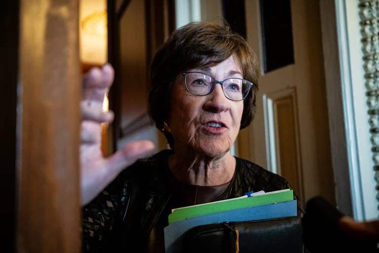 Senator Susan Collins speaks and holds a few folders