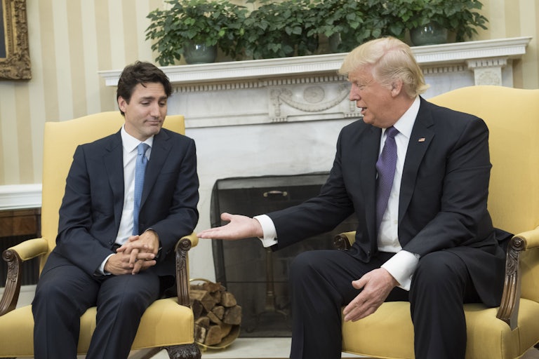 Justin Trudeau looks skeptically at Donald Trump, who is offering him his hand.