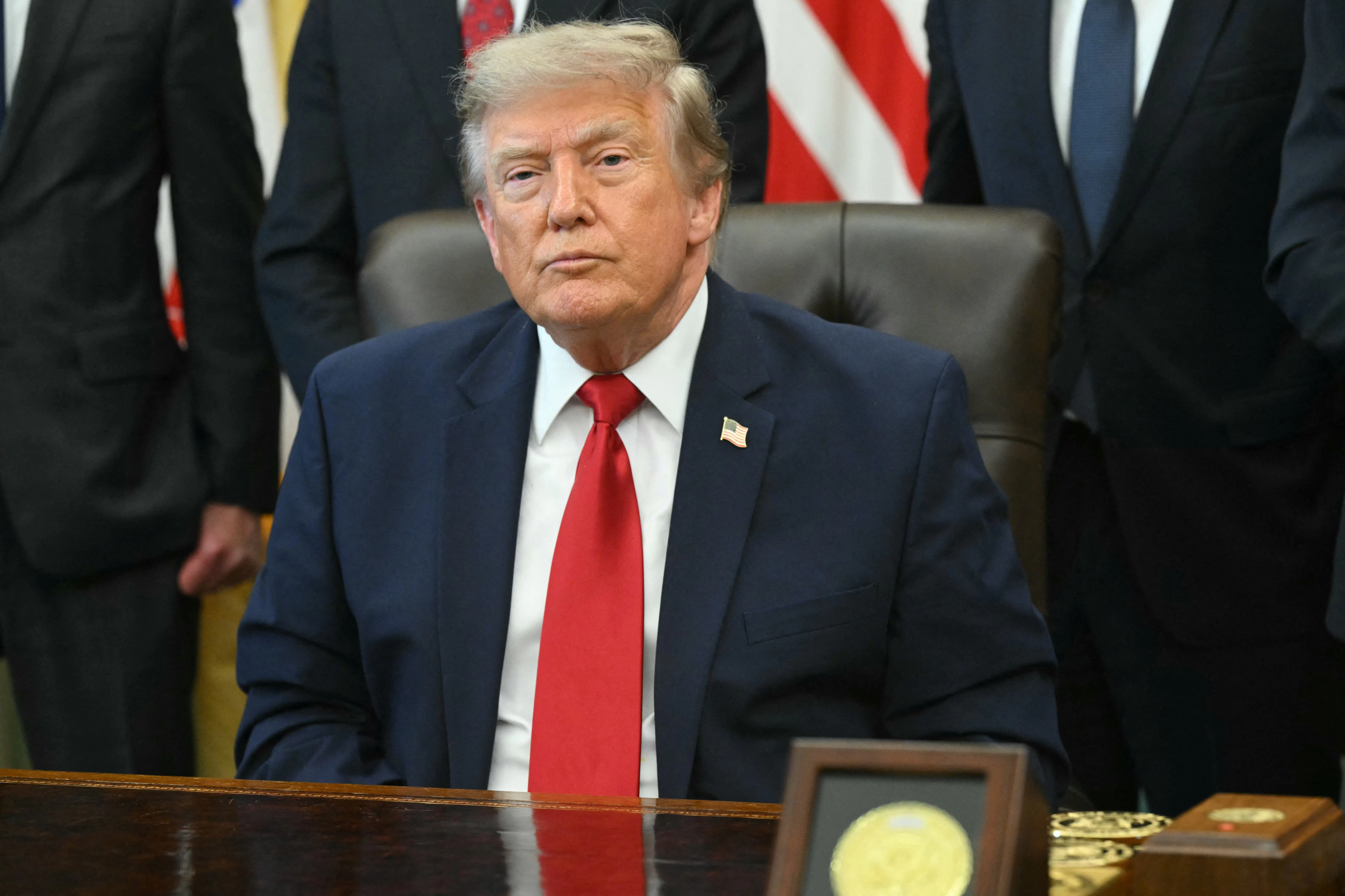 Donald Trump sits at his desk in the Oval Office
