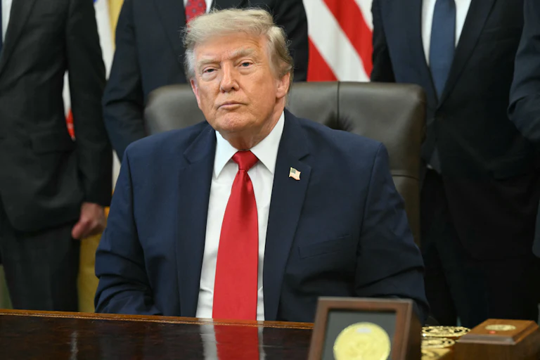 Donald Trump sits at his desk in the Oval Office