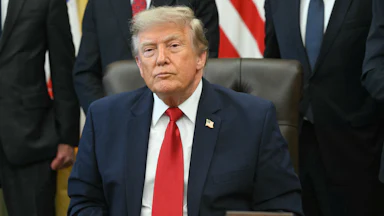 Donald Trump sits at his desk in the Oval Office