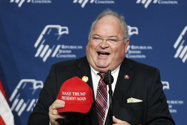 Billy Long, Trump’s nominee to lead the IRS, laughs while holding a Make America Great Again cap.
