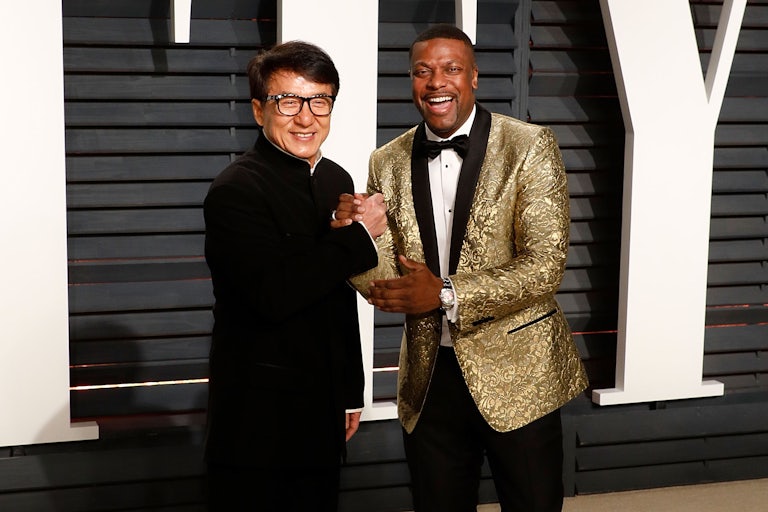 Jackie Chan and Chris Tucker grasp each other's hands as they smile for the cameras.