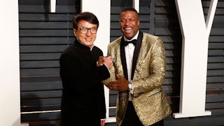 Jackie Chan and Chris Tucker grasp each other's hands as they smile for the cameras.