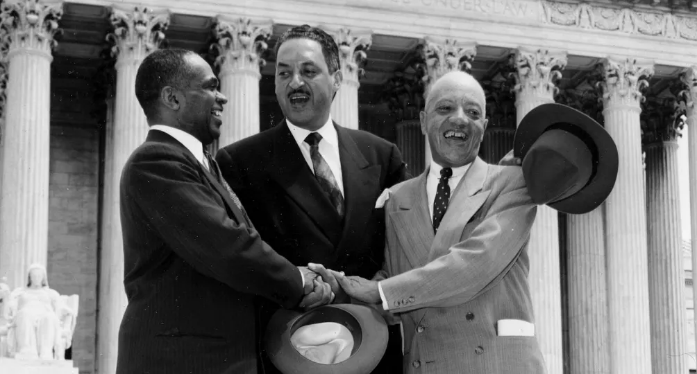 A photo from May 17, 1954 showing George E.C. Hayes, Thurgood Marshall, and James M. Nabrit joining hands after the ruling on Brown v. Board of Education that school segregation is unconstitutional.