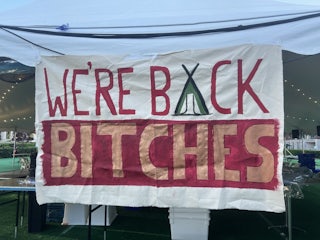 Sign reads "We're Back Bitches"