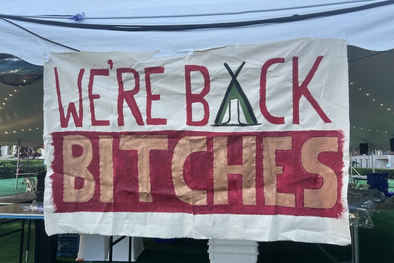 Sign reads "We're Back Bitches"