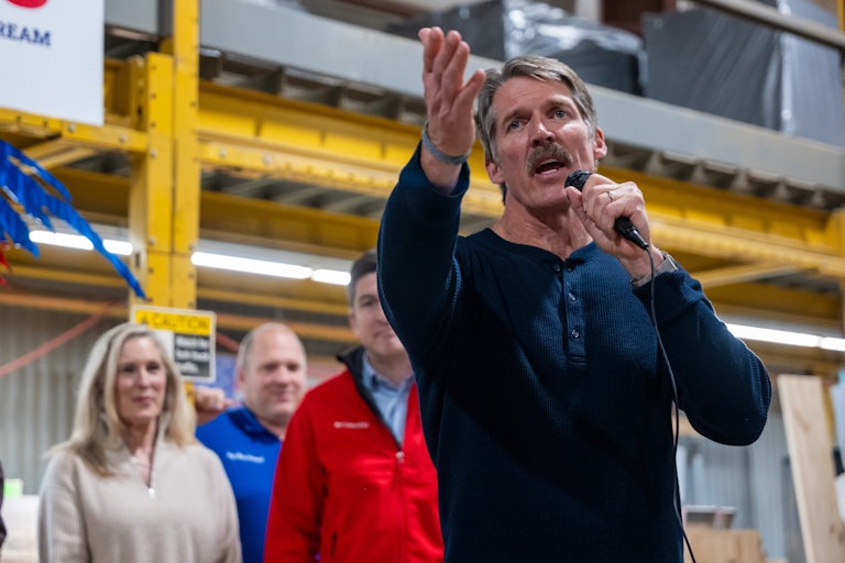 Wisconsin Republican Senate Candidate Eric Hovde speaking with a mic in his hand, as others look on