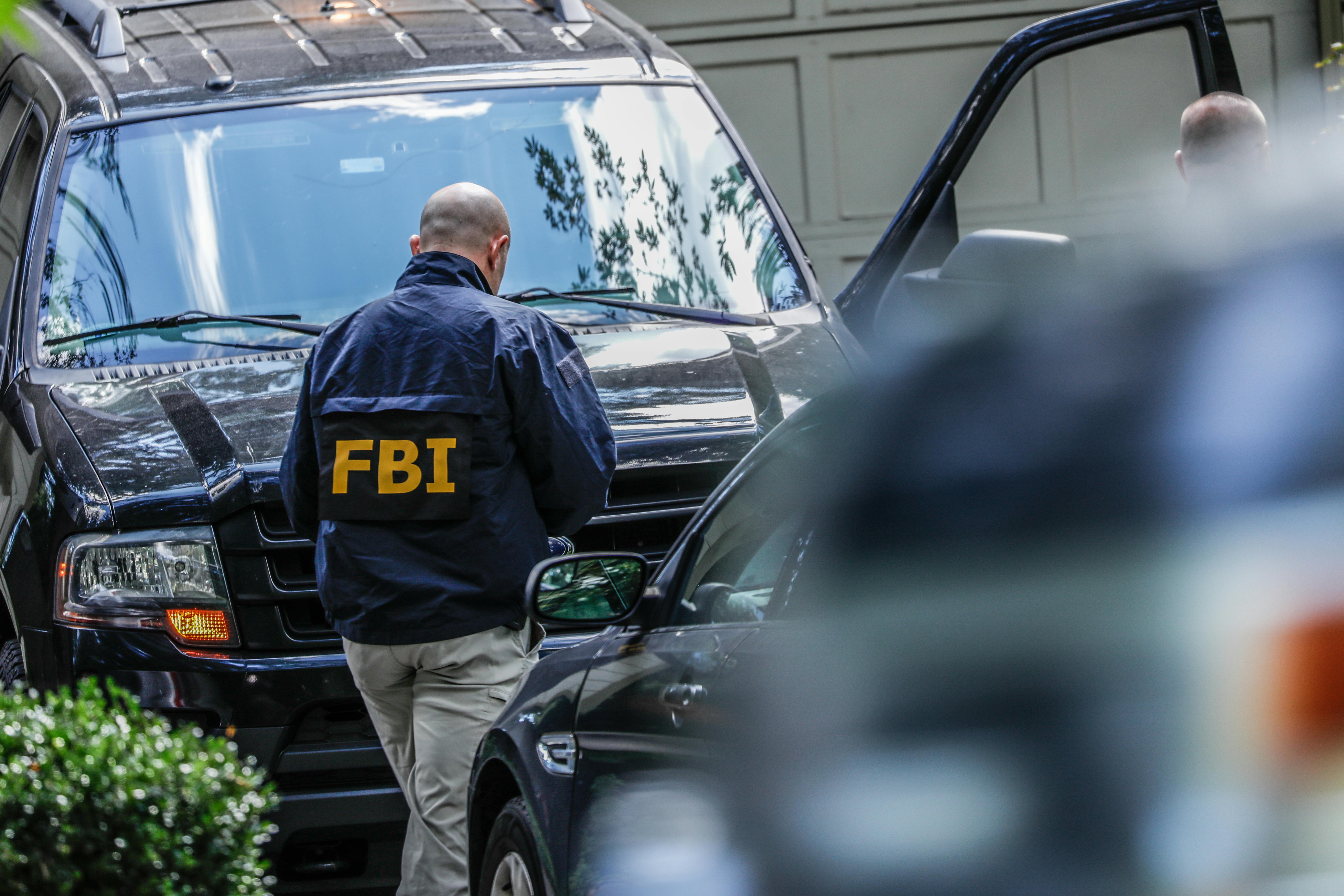 An FBI agents walks to his car.