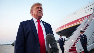 Donald Trump stands next to Air Force One