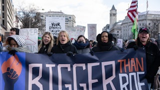 Demonstrators carry a banner reading "Bigger Than Roe."