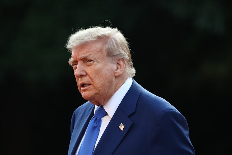 Donald Trump walks outside The Hague
