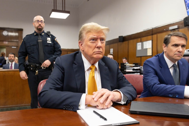 Donald Trump folds his hands while he sits in a Manhattan court room.