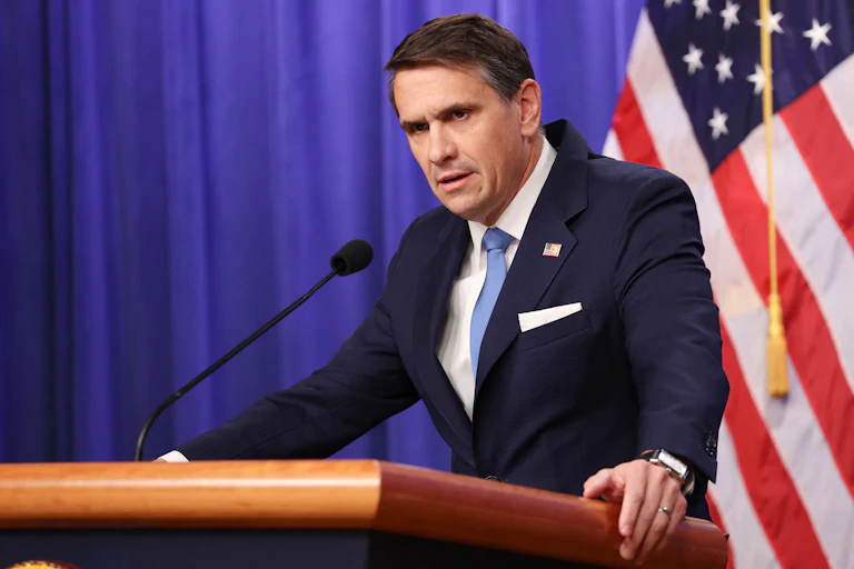 Attorney General Todd Blanche stands behind a lectern looking shifty