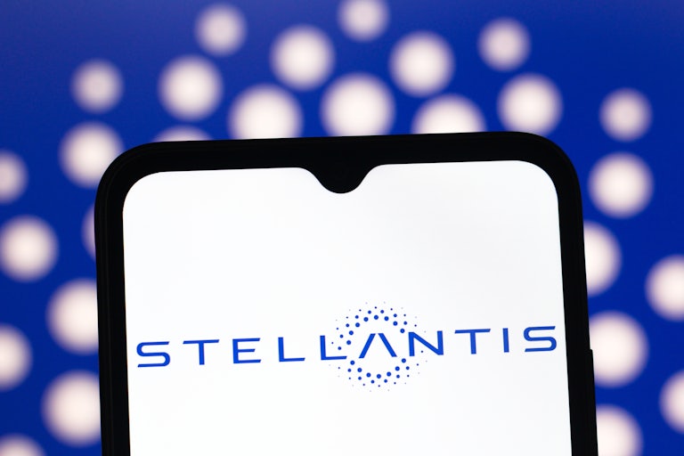 A phone screen displays the Stellantis logo