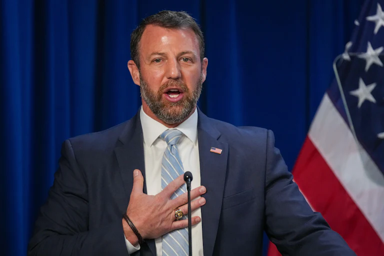 Homeland Security Secretary Markwayne Mullin puts his hand on his chest while speaking into a microphone