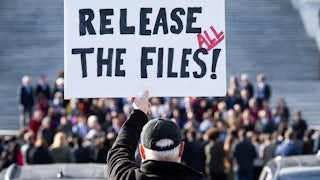 A person holds up a sign that says, "Release all the files!" during a press conference