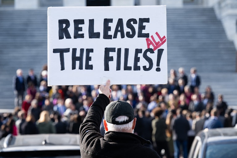 A person holds up a sign that says, "Release all the files!" during a press conference