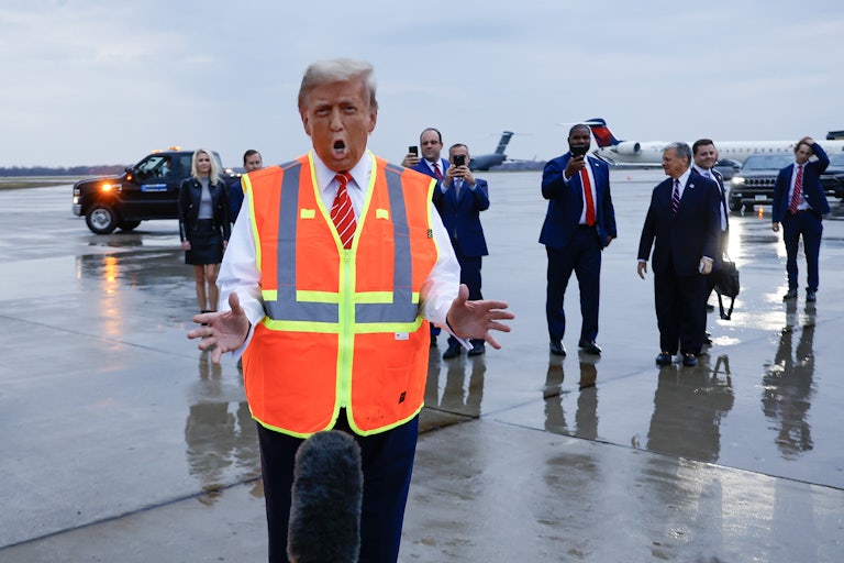 Donald Trump gestures while wearing a traffic vest