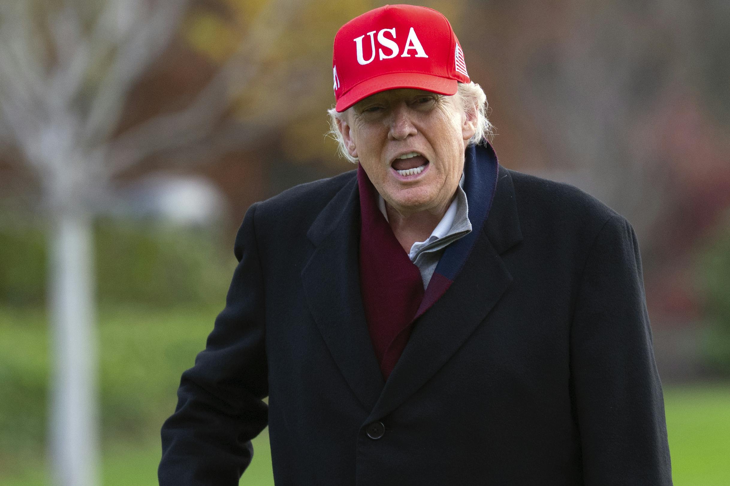 Donald Trump yells wearing a red USA hat