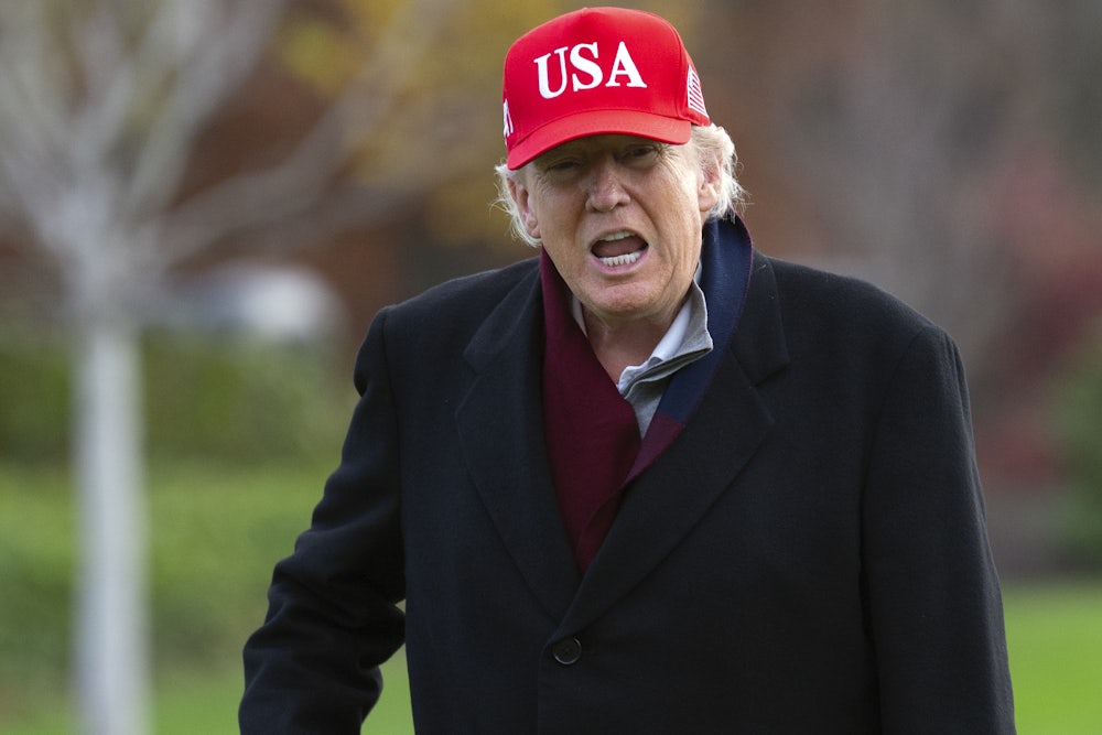 Donald Trump yells wearing a red USA hat
