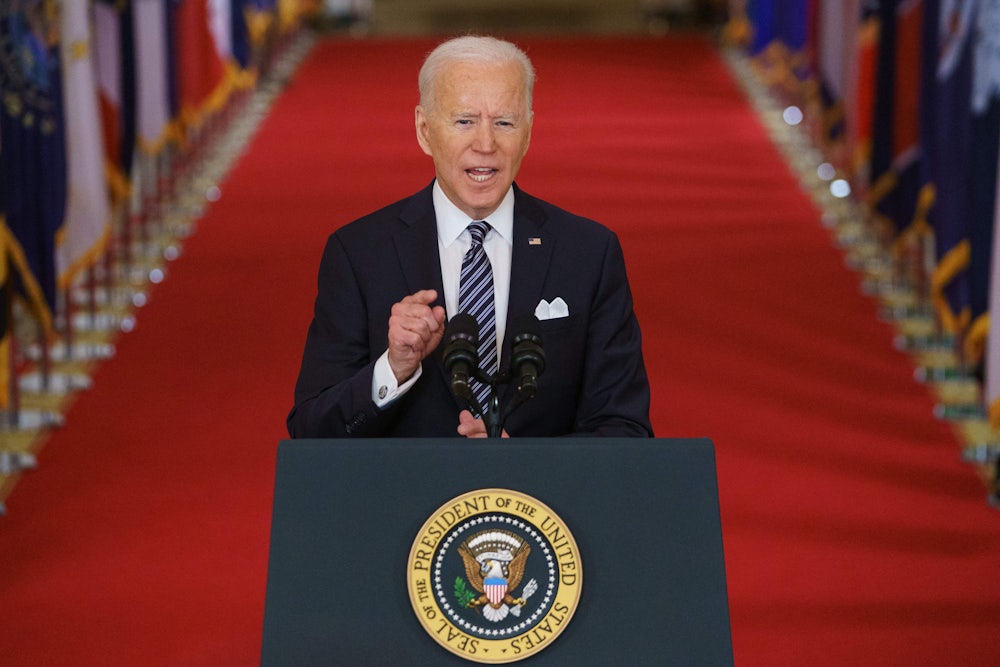Joe Biden at a microphone, giving a speech about the coronavirus pandemic in the East Room of the White House
