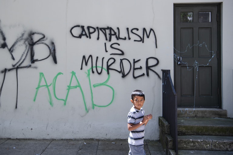 A child walks by graffiti in Washington D.C. on H St. NW near the White House, on Monday, June 1, 2020.