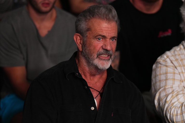Mel Gibson sits in the stands and makes a grimace.