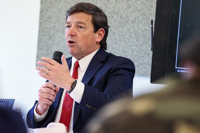 Ed Martin gestures and speaks while holding up a microphone