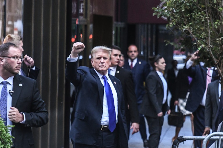 Donald Trump holds up his fist as he walks