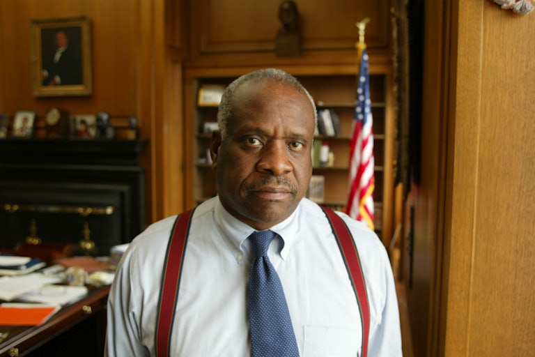 Supreme Court Justice Clarence Thomas stands in his office.