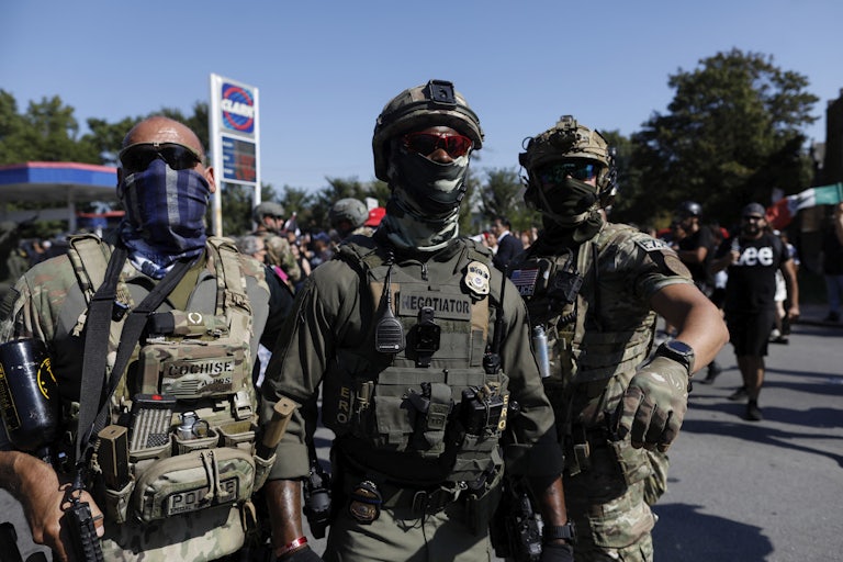 Three ICE officers stand in front of a gas station in Chicago