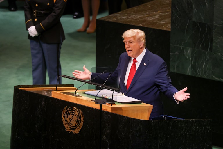 Donald Trump holds his arms out to the side as he speaks at the lectern in the UN General Assembly