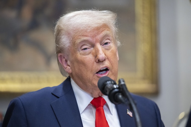 Donald Trump makes a weird face while speaking at a podium in the White House.