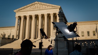 Television crews set up in front of the Supreme Court building.