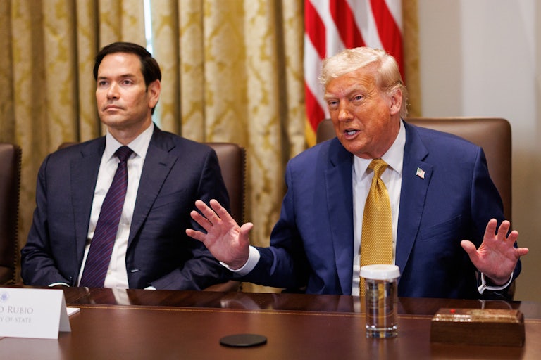Marco Rubio sits next to Donald Trump in a Cabinet meeting. Trump gestures and speaks