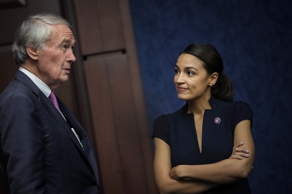 Senator Ed Markey and Representative Alexandria Ocasio-Cortez talk while standing.
