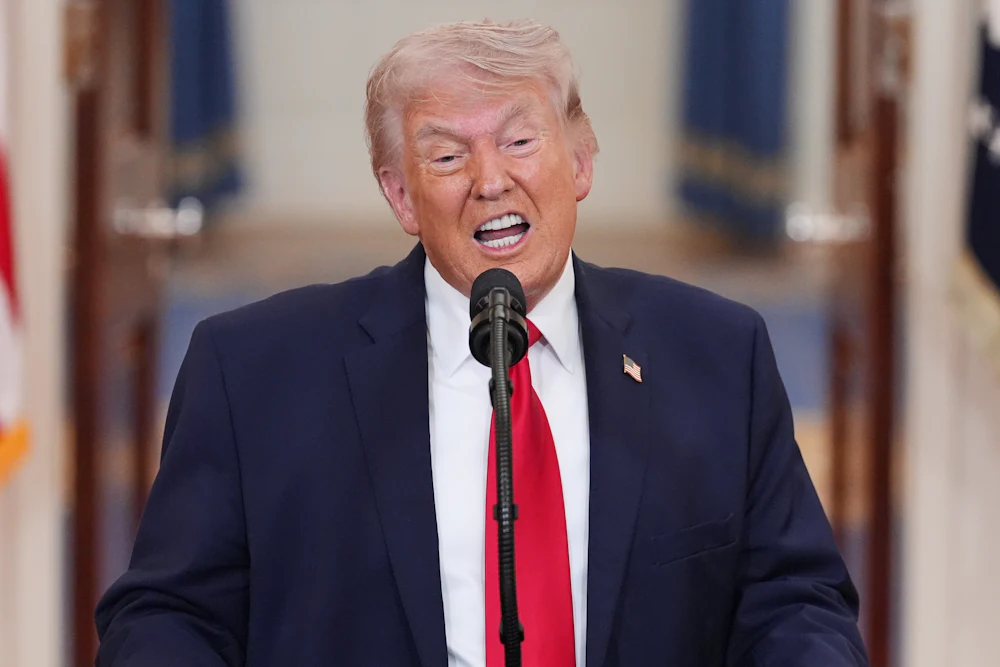 Donald Trump speaks into a microphone with teeth bared