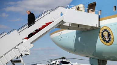 Donald Trump looks down while walking down the stairs from Air Force One