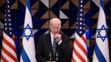 President Joe Biden speaks at a lecturn. Israeli and U.S. flags are behind him.