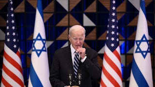 President Joe Biden speaks at a lecturn. Israeli and U.S. flags are behind him.