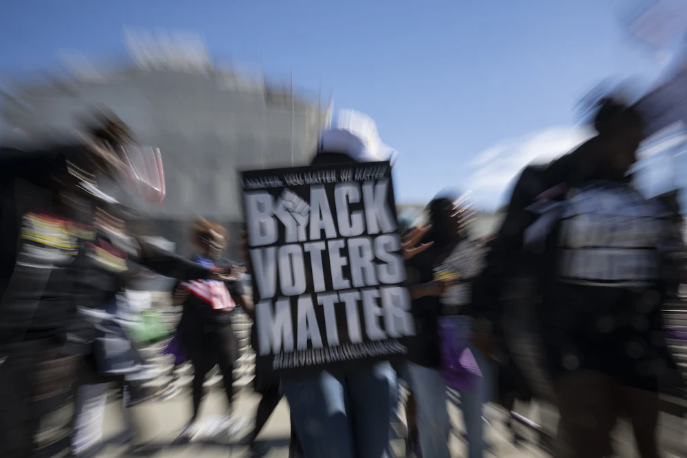 Demonstrators hold signs in support of minority voting rights outside the U.S. Supreme Court in Washington, D.C.