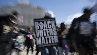 Demonstrators hold signs in support of minority voting rights outside the U.S. Supreme Court in Washington, D.C.