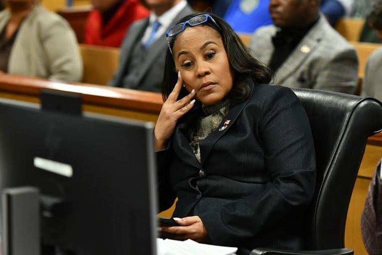 Fani Willis rests her head on her head and looks defeated