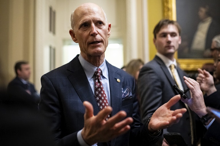 Senator Rick Scott gestures while speaking to reporters in the Capitol