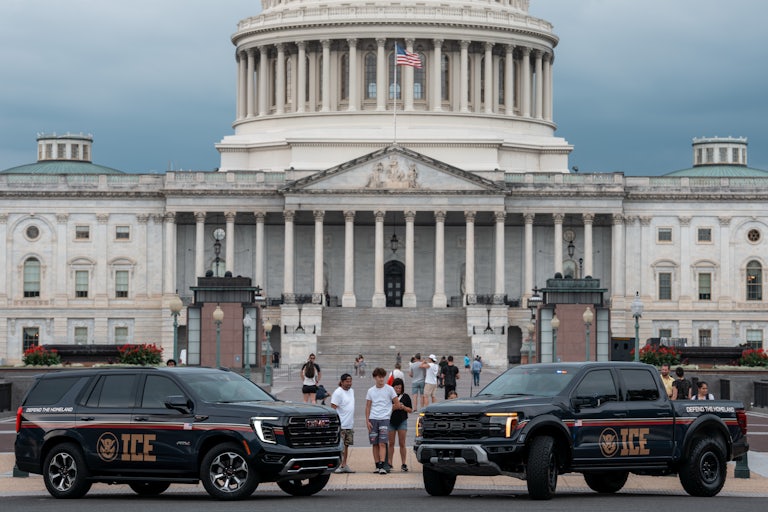 ICE-branded SUVs are parked in front of the Capitol