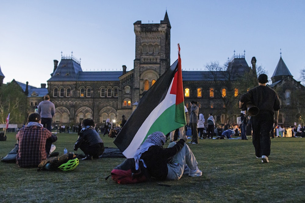 A demonstrator holds a Palestinian flag at a pro-Palestine encampment at the University of Toronto