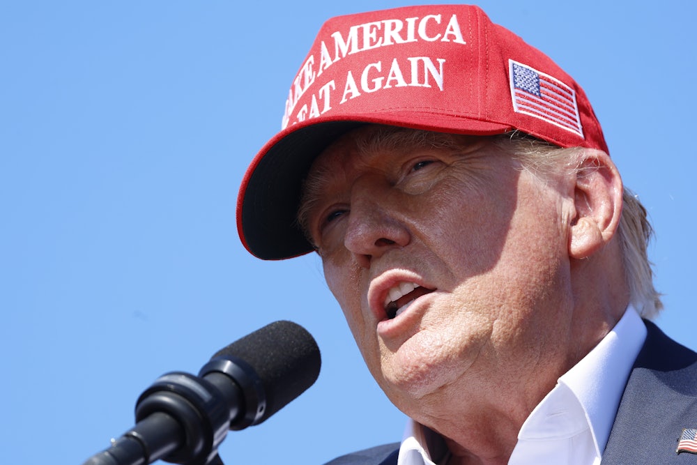 Trump speaks at a rally while wearing a MAGA hat