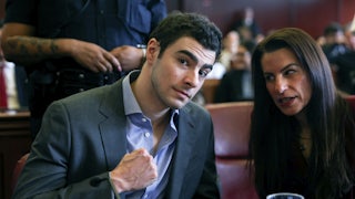 Luigi Mangione flexes for the camera as his lawyer speaks to him.